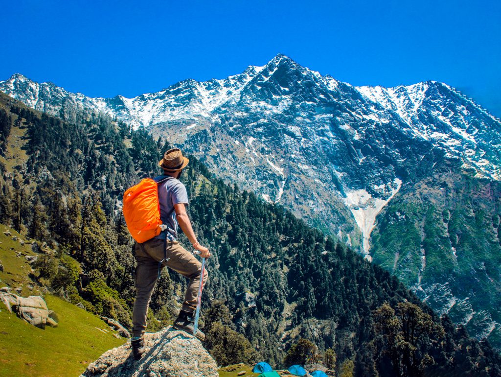 homme avec un sac à dos randonnée en haut d'une montagne