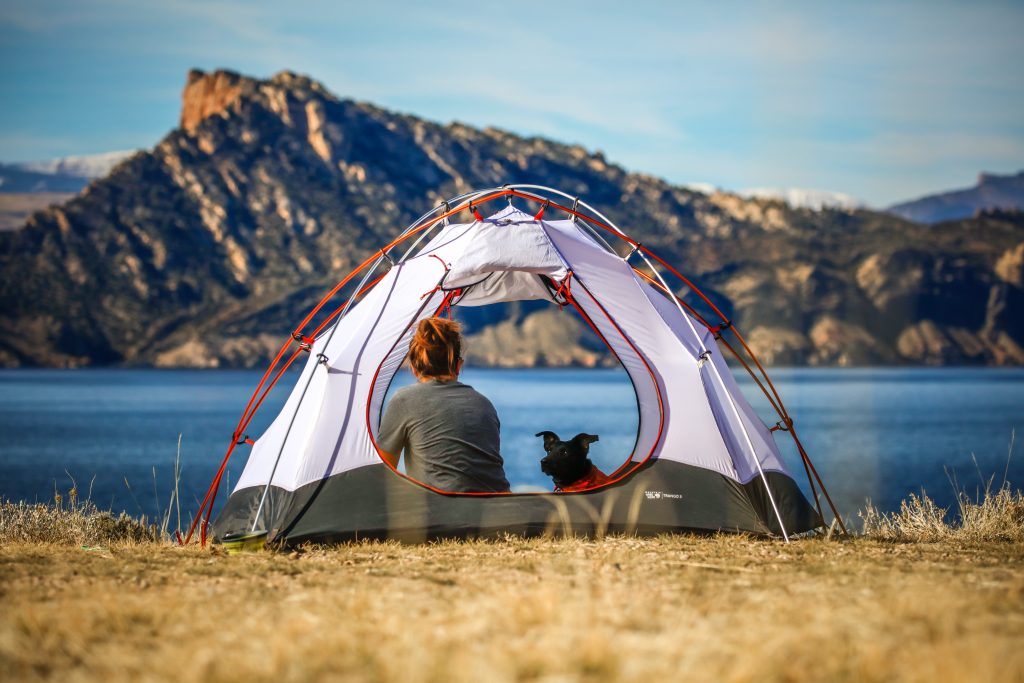 femme dans une tente qui regarde un lac