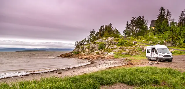 Van aménagé garé sur une plage