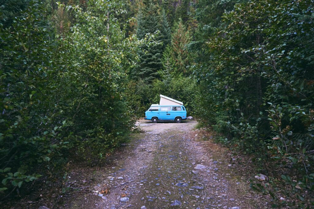 Van avec toit relevé en plein milieu de la forêt au bout d'un chemin