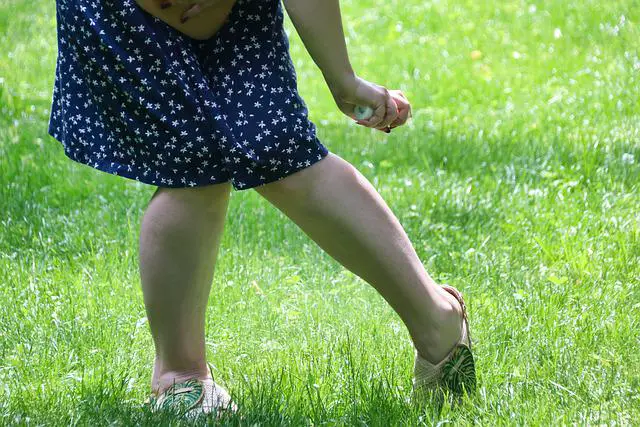 une femme qui mets du répulsif anti-moustiques sur ses jambes